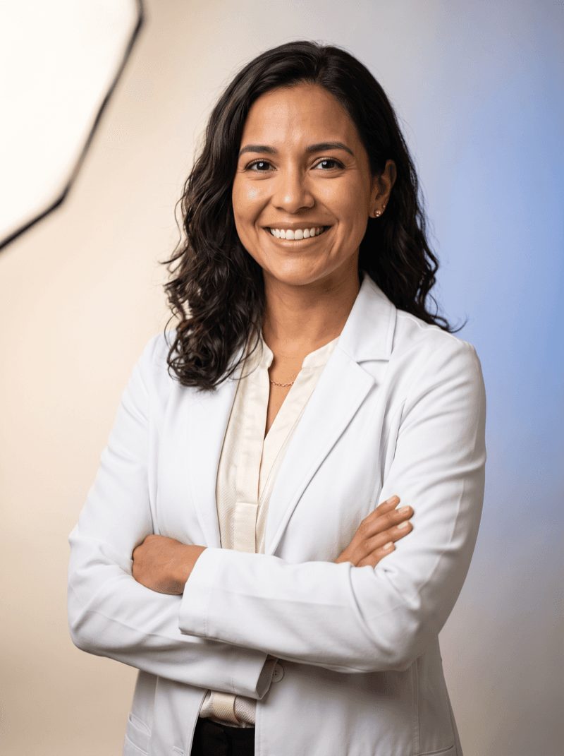 Médica sonriente con bata blanca y los brazos cruzados